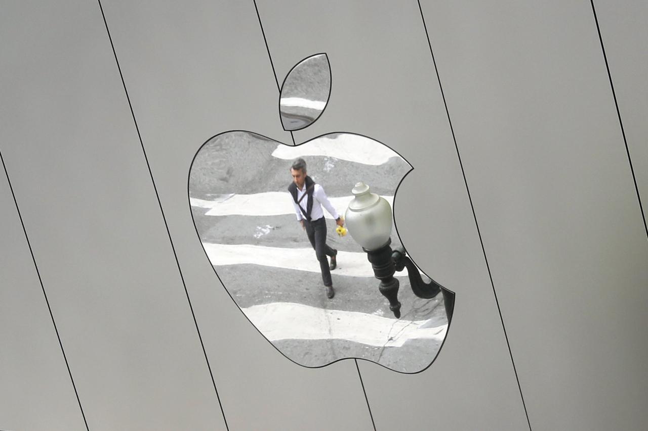 FILE PHOTO: A man is reflected in a Apple store logo in San Francisco, California, U.S., August 21, 2017.   REUTERS/Kevin Coombs/File Photo